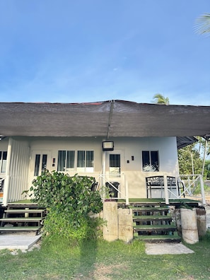 A two-story building with a covered entrance, a small garden area, and a visible door. - Summer Sunshine Resort Songkhla (Songkhla)