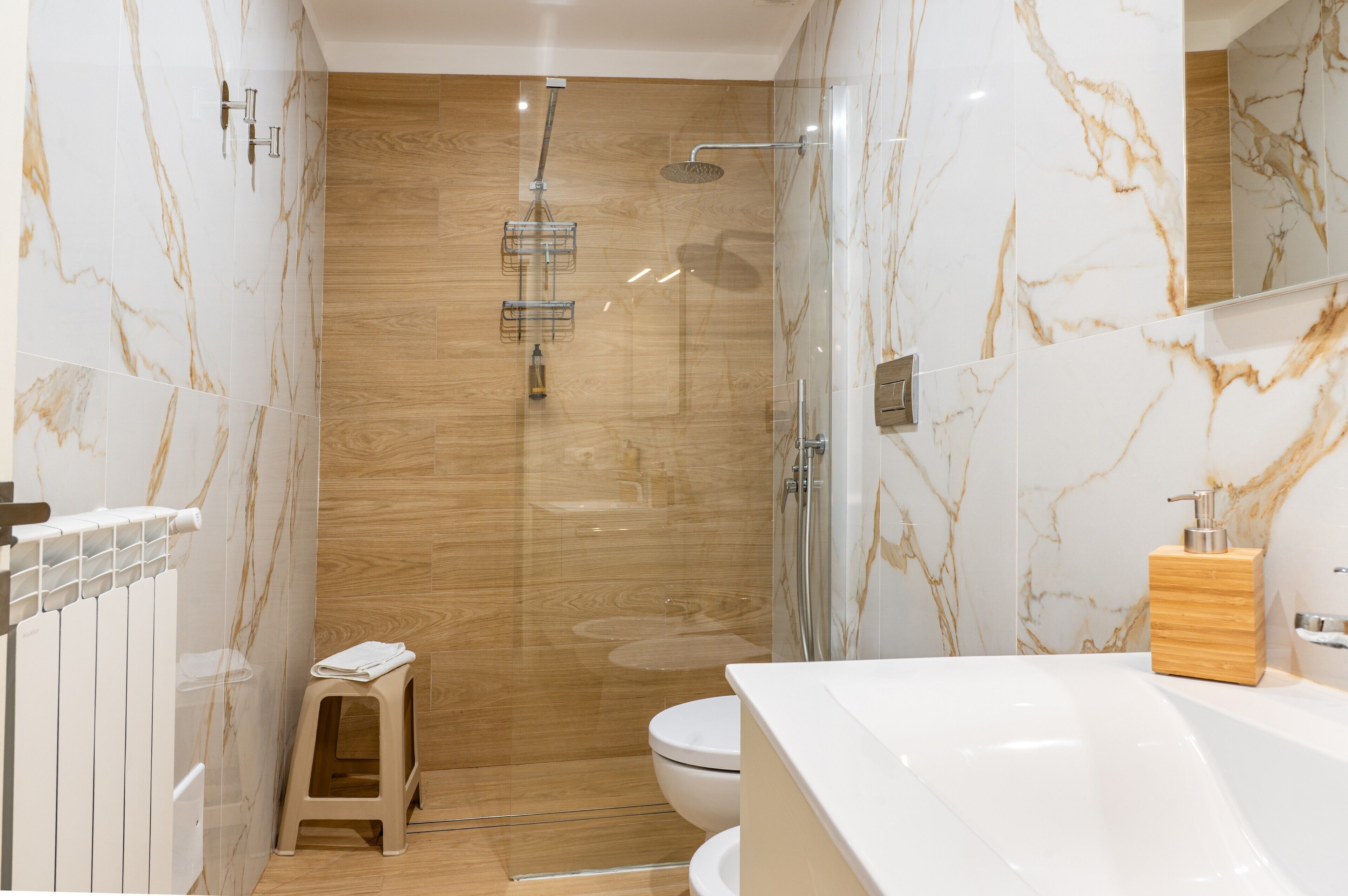 A modern bathroom with a shower, toilet, and a vanity with a mirror.