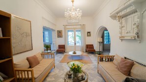 A spacious living room with a chandelier, sofas, a coffee table, and a bookshelf. - Dar Marsa Cubes 5-suite Serviced Villa Chef Housekeeper La Marsa (La Marsa)