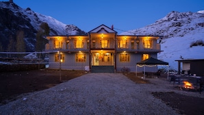 Ein zweigeschossiges Gebäude mit einem zentralen Eingang, zahlreichen Fenstern und einer Schotterauffahrt.