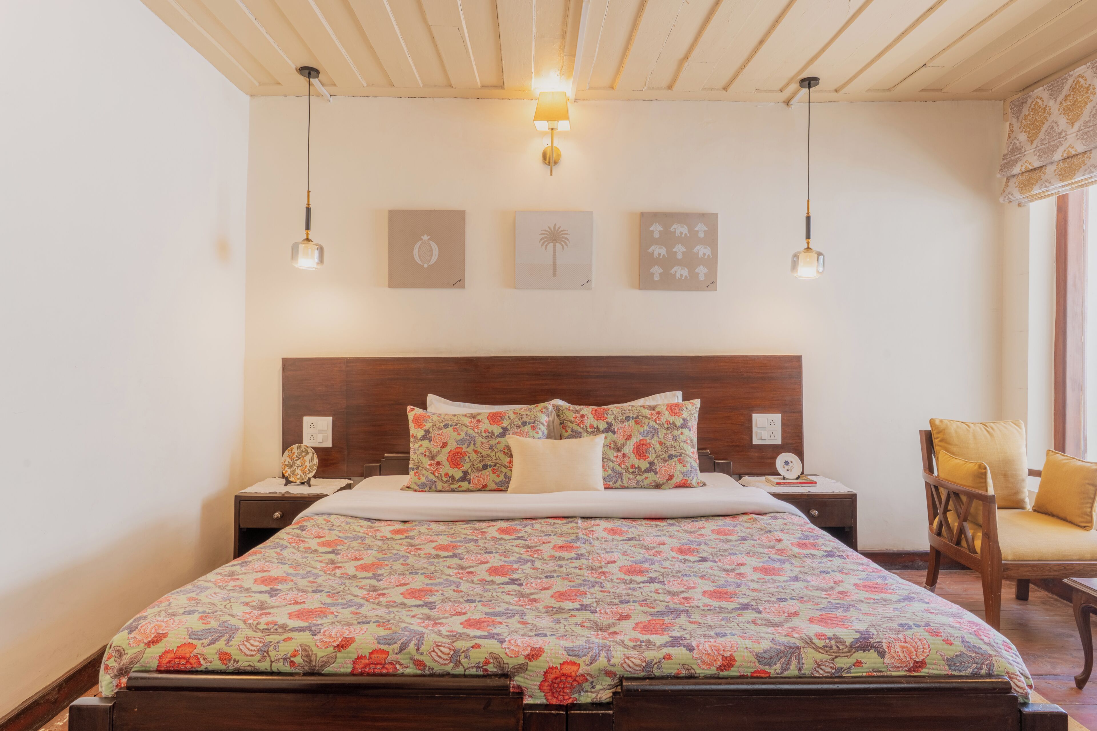Een slaapkamer met een houten bed, twee nachtkastjes, een stoel en wanddecoratie.