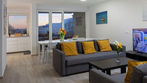 Una sala de estar moderna con sofá, mesa de centro y televisor.