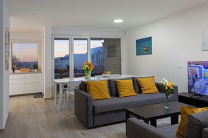 A modern living room with a sofa, coffee table, and a TV. - Villa Aster (Privlaka)