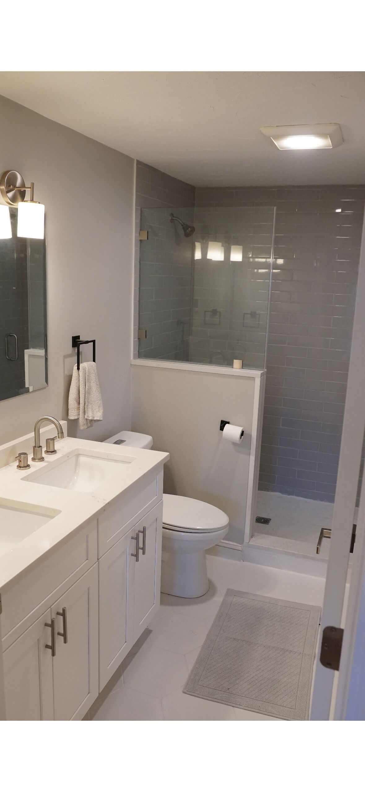 Une salle de bain moderne dotée d’un grand lavabo, de toilettes et d’un espace douche.