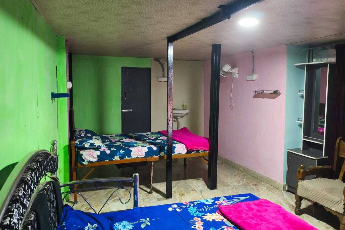 Una habitación con dos camas, un lavamanos, un espejo y una silla.
