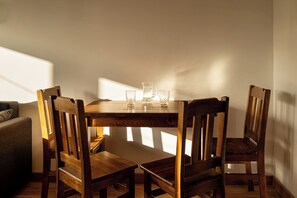 Ein Holzespeisesaal mit vier Stühlen, einer Karaffe und zwei Gläsern.