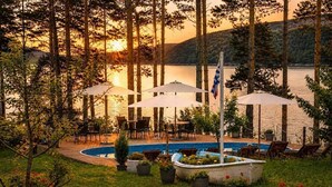 A poolside area with outdoor seating and a flagpole. - Club Paradise Bay Iskar Lake (Sofia)