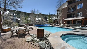A pool area with lounge chairs, a hot tub, and a building with multiple windows. - Steps to Keystone Weddings, Gondola, Dining! 3 Hot Tubs, Pool, Elevator (Keystone)