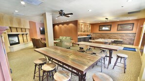 A spacious room with a large wooden table, multiple bar stools, a fireplace, and a television. - Steps to Keystone Weddings, Gondola, Dining! 3 Hot Tubs, Pool, Elevator (Keystone)