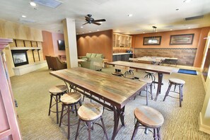 A spacious room with a large wooden table, multiple bar stools, a fireplace, and a television. - Steps to Keystone Weddings, Gondola, Dining! 3 Hot Tubs, Pool, Elevator (Keystone)