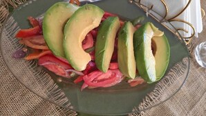 A plate with sliced avocado and red onions. - kilimanjaro safari lodge (Moshi)
