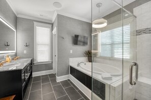 A modern bathroom with a glass shower enclosure, a large bathtub, and a vanity with dual sinks. - Kiser Island (Terrell)