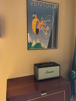 Ein gerahmtes Poster mit einem Mountainbiker, ein Vintage-Verstärker und ein Holzschrank.