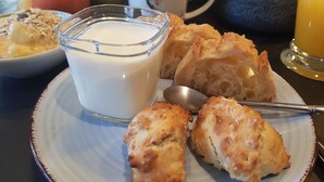 Une assiette de petit-déjeuner avec du lait, des viennoiseries et une cuillère.