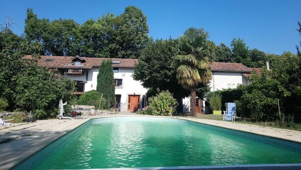 Une piscine avec un bâtiment blanc en arrière-plan.