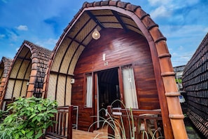 A wooden cottage with a sloped roof, a small porch, and a visible number '4' on the front. - Hotel O near Mookiland Park Bali formerl (Kerobokan)