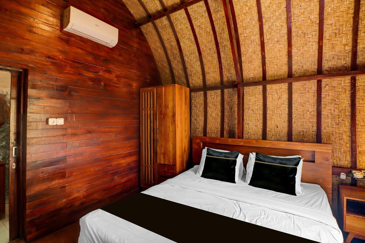 Une pièce en bois comprenant un lit, une armoire et un appareil de climatisation.