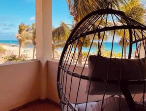A corner room with a view of the beach, a hanging chair, and a window. - Terrace with sea views! #Amazing sea views! (Santa Maria)