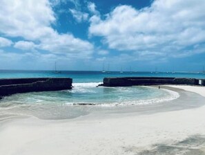 A beach with calm waters, a clear sky, and distant sailboats. - Terrace with sea views! #Amazing sea views! (Santa Maria)