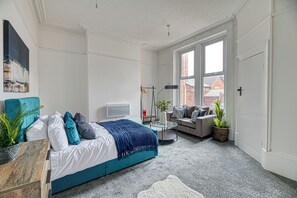 A modern bedroom with a bed, sofa, and a small table. - Glendale House by Guestz (Lytham-St-Annes)