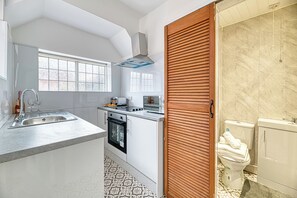 A modern kitchen with a built-in oven, a sink, and a window. - Glendale House by Guestz (Lytham-St-Annes)