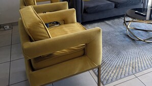 A modern living room with a yellow armchair, a dark sofa with yellow cushions, and a glass coffee table. - 2 minutes to the mall, restaurants gym, shops all amenities 2 minutes away. (Sandton)