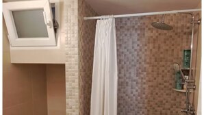 A bathroom with a shower, toilet, and a window. - Central Paroikia Apartment - 10min walk to Port and Beach! (Paros)