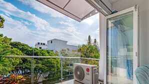 Ein Balkon mit Glastür, einem Blumentopf und einer LG-Klimaanlage.