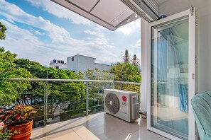 A balcony with a glass door, a potted plant, and an LG air conditioning unit. - Modern 2BR with pool in Tequendama Cali. (Cali)