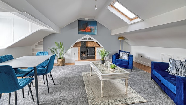 A spacious loft with a dining area, seating, a fireplace, and a skylight. - Glendale House by Guestz (Lytham-St-Annes)