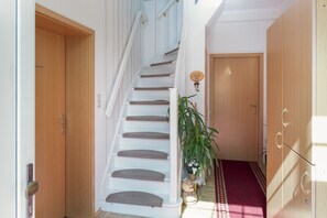 Una escalera con escalones blancos y una puerta de madera al final.