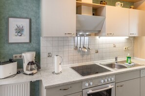 A kitchen with a coffee maker, toaster, sink, and an oven. - Apartment 'Für 2 Personen 45 M²' with Private Terrace and Wi-Fi (Bad Wilsnack)