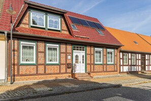 A traditional half-timbered building with a sloped roof, solar panels, and a small porch area. - Apartment 'Für 2 Personen 45 M²' with Private Terrace and Wi-Fi (Bad Wilsnack)