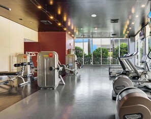 A gym with cardio machines, weight equipment, and large windows offering a view of the outdoors. - Beachwalk Studio Intracoastal & Balcony (Hallandale Beach)