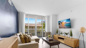 Una sala de estar moderna con un sofá, una mesa de centro y un televisor montado en la pared.