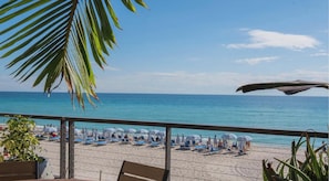 A beach with umbrellas and lounge chairs, a clear sky, and a view of the ocean. - Beachwalk Resort · 2BR · Intracoastal View (Hallandale Beach)