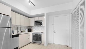 Una cocina moderna con electrodomésticos de acero inoxidable, lavavajillas y microondas.