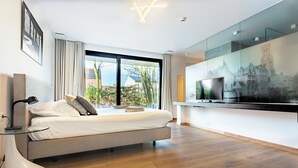 A modern bedroom with a bed, a TV, and a large window. - Huyze Fox (Bruges)