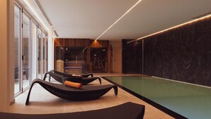 A modern indoor pool area with lounge chairs, a wooden wall, and a glass door leading outside. - Huyze Fox (Bruges)