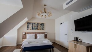 Ein modernes Schlafzimmer mit einem großen Bett, einer Chandelier, einem Gemälde, einem Fernseher und einem Holzkasten.