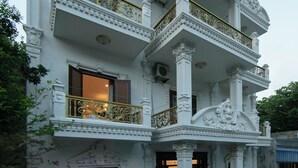 A multi-story building with ornate architectural details, including columns and balconies. - Rose Wood Cat Ba Villa (Hai Phong)
