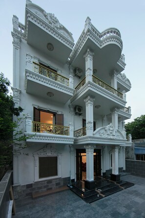 Un edificio de varios pisos con detalles arquitectónicos ornamentales, incluyendo columnas y balcones.