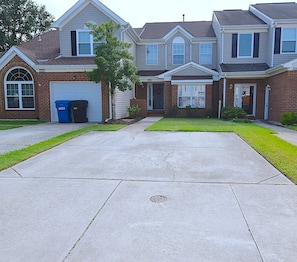 A residential house with a garage, a front yard, and a driveway.