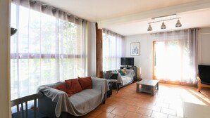 Ein Wohnzimmer mit einer Couch, einem Fernseher und einem Tisch.