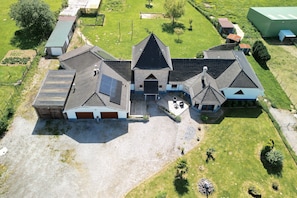A large, multi-story building with a central entrance, surrounded by a well-maintained lawn and a gravel driveway. - Holiday Home "Gîte du Tronquoy" with Private Terrace, Garden and Wi-Fi (Aix-en-Ergny)