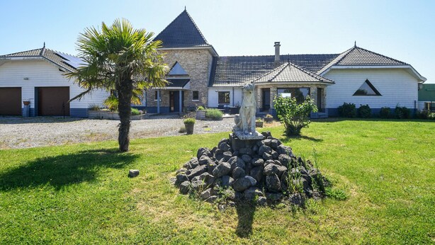 A two-story house with a stone facade, a tiled roof, and a well-maintained lawn. - Holiday Home "Gîte du Tronquoy" with Private Terrace, Garden and Wi-Fi (Aix-en-Ergny)