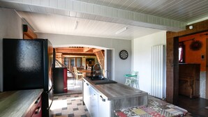 A kitchen with a black refrigerator, a wooden countertop, a patterned tile backsplash, and a view into the dining area. - Holiday Home "Gîte du Tronquoy" with Private Terrace, Garden and Wi-Fi (Aix-en-Ergny)