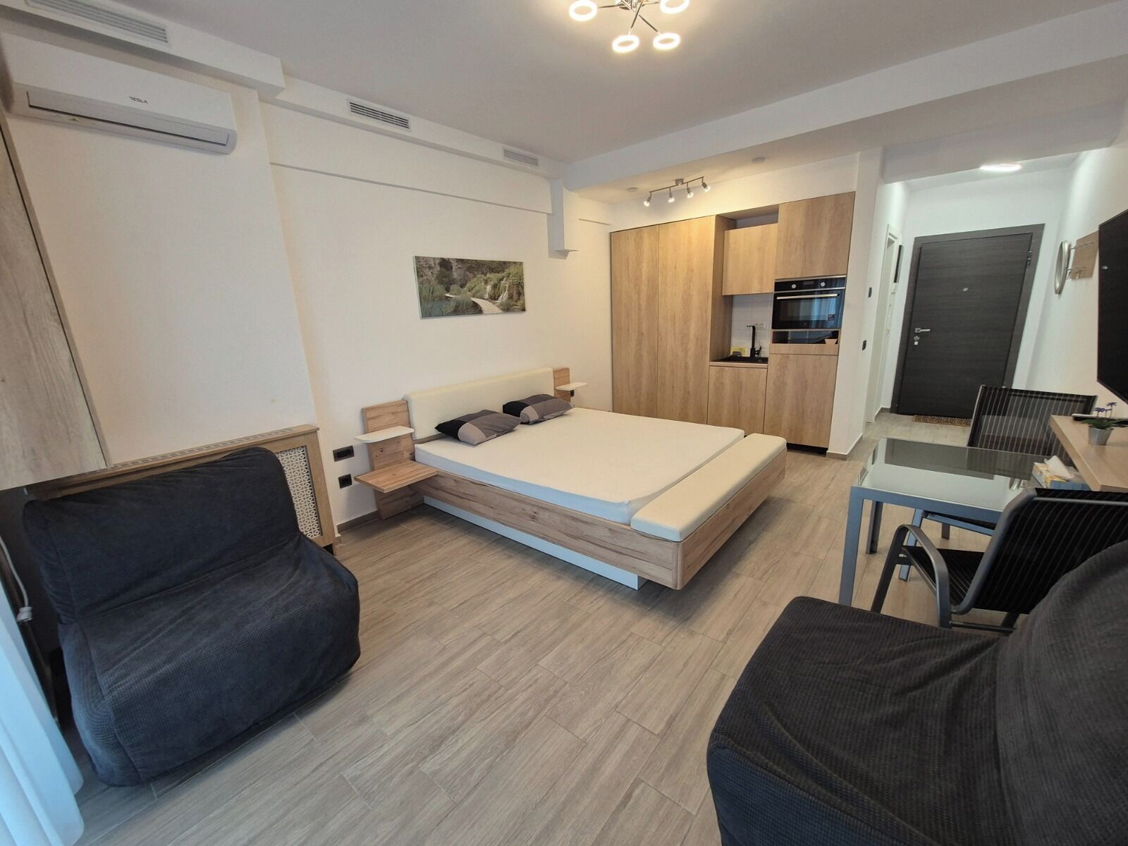 Une chambre moderne équipée d’un lit, d’un bureau et d’une kitchenette.
