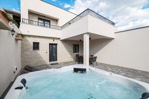 Une maison moderne dotée d’un jacuzzi, d’un balcon et d’un coin repas.