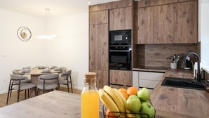 A modern kitchen with wooden cabinets, a built-in microwave, and a sink. - Villa Ruzarija with jacuzzi (Sukošan)